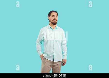 Portrait d'un homme millénaire souriant, beau et confiant, sur fond bleu clair. Banque D'Images