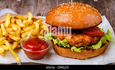 Savoureux hamburger au poulet avec frites sur une table en bois Banque D'Images