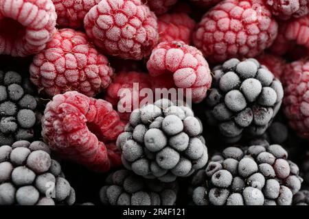 Framboises et mûres surgelées savoureuses comme arrière-plan, vue de dessus Banque D'Images