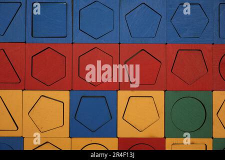 Puzzle en bois avec différentes formes géométriques et couleurs comme arrière-plan, vue de dessus. Jouet Montessori Banque D'Images