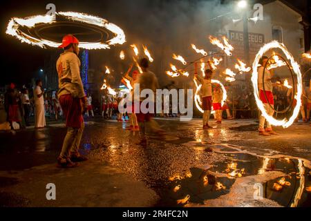 Les danseurs de boule de feu se produisent le long d'une rue pendant le bouddhiste Esala Perahera (grande procession) à Kandy au Sri Lanka. Banque D'Images
