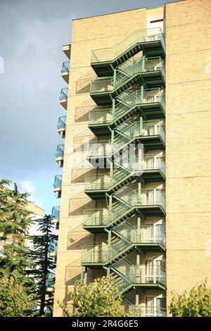 Vue sur l'échelle d'évacuation de feu vide en métal moderne près du bâtiment pendant la journée ensoleillée à l'extérieur Banque D'Images