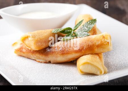 Crêpes roulées avec sucre en poudre et menthe Banque D'Images