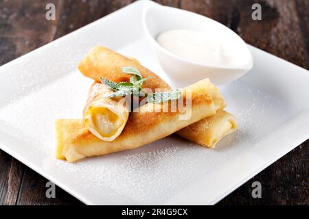 Crêpes roulées avec sucre en poudre et menthe Banque D'Images