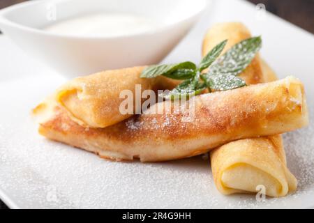 Crêpes roulées avec sucre en poudre et menthe Banque D'Images