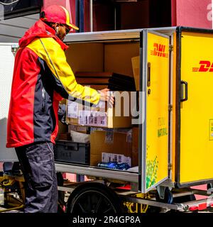 Stavanger, Rogaland, Norvège, 19 mai 2023, travailleur local décharger et livrer des colis DHL à partir D'Un chariot ou d'un chariot de marque Banque D'Images