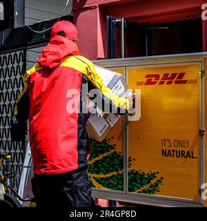 Stavanger, Rogaland, Norvège, 19 mai 2023, travailleur local décharger et livrer des colis DHL à partir D'Un chariot ou d'un chariot de marque Banque D'Images