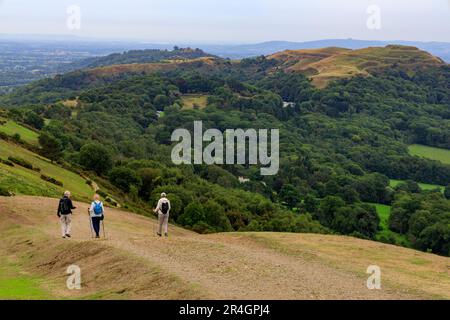 Marcheurs descendant de Black Hill sur les collines de Malvern avec British Camp/Herefordshire Beacon terrassement à distance, Worcestershire, Angleterre, Royaume-Uni Banque D'Images