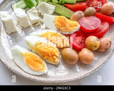 petit déjeuner, assiette de petit déjeuner saine avec des tranches d'œufs durs, du fromage et de la salade fraîche sur l'assiette avec un accent sélectif. concept alimentaire sain et délicieux Banque D'Images