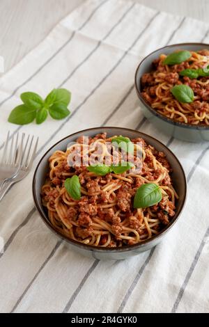 Spaghetti à la saucisse de basilic aux tomates maison dans un bol, vue latérale. Banque D'Images