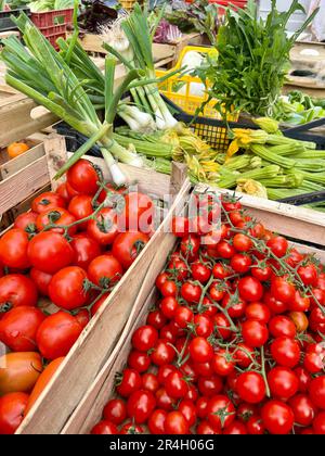 marché agricole, gros plan de délicieuses tomates cerises mûres et légumes frais dans un marché d'épicerie. tas de salade fraîche brute et fond de légumes ou s Banque D'Images