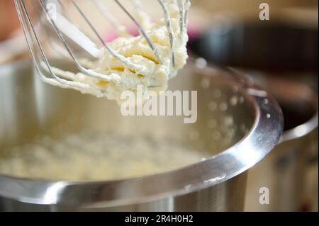 Le processus de fouetter la crème pour obtenir des pics fermes ou des blancs d'œufs dans le mélangeur planétaire. Crème fouettée pour gâteaux et desserts sucrés Banque D'Images