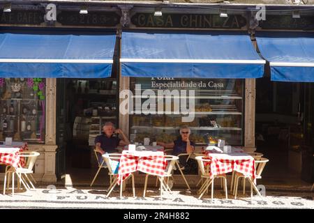 Couple assis à l'ombre devant le café casa chineza dans le centre de Lisbonne Banque D'Images