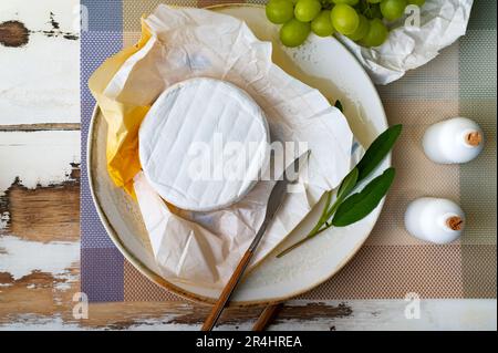 Fromage Camembert sur l'assiette avec des raisins et des herbes Banque D'Images