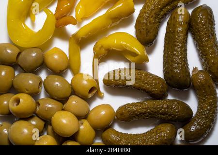 Gros plan d'antipasti avec olives, cornichons et poivrons chauds sur fond blanc Banque D'Images