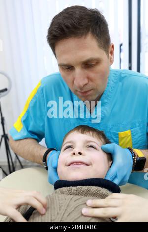 L'ostéopathe traite les organes respiratoires du garçon en clinique Banque D'Images