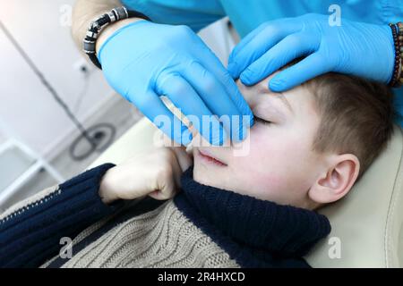 L'ostéopathe traite le système respiratoire de l'enfant sur le lit en clinique Banque D'Images