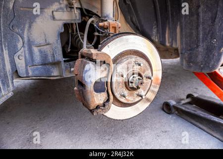 Disque de frein de voiture usé en gros plan. Réparation des freins d'une voiture. Remplacement des roues et des freins. Freins à disque rouillés d'une voiture Banque D'Images