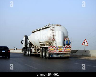 Le Caire, l'Egypte, le 20 mai 2023: Un gros camion avec un réservoir contenant des produits pétroliers, un camion sur la route avec un conteneur sur lui livrant le pro Banque D'Images