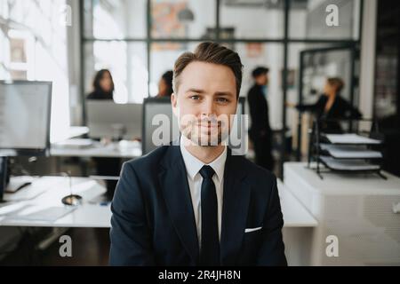 Portrait d'un entrepreneur masculin portant un blazer noir au bureau Banque D'Images