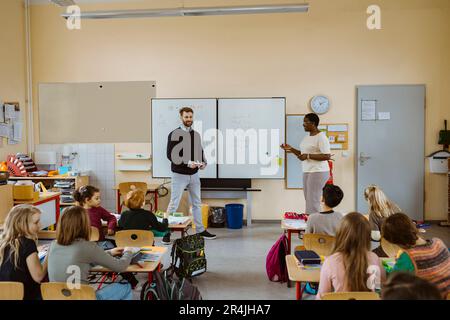 Les enseignants de sexe masculin et féminin enseignent les mathématiques aux élèves en classe Banque D'Images