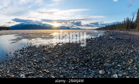 Vue imprenable sur le coucher du soleil en Colombie-Britannique au printemps avec coucher du soleil sur les montagnes enneigées sur le lac rocheux, paysage sauvage Banque D'Images