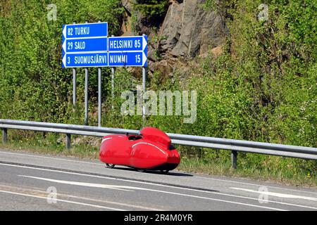 Voyage avec Velomobiel à quatre roues rouge Quattrovelo velomobile sur l'autoroute 110, signalisation routière indiquant les distances. Salo, Finlande. 20 mai 2023. Banque D'Images