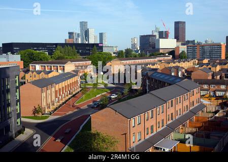 Des tours et des maisons de ville dans la région de Brunswick de la ville sous le soleil tôt le matin à Manchester, Royaume-Uni. Banque D'Images