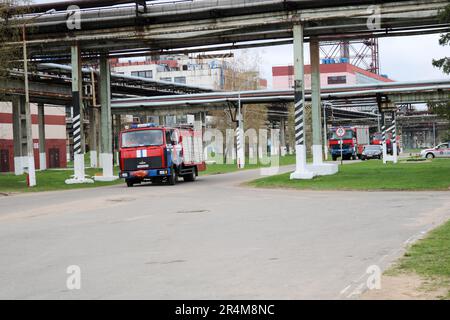 Un gros véhicule de secours rouge de lutte contre l'incendie, un camion d'extinction d'incendie, se trouve dans une raffinerie de pétrole chimique. Banque D'Images