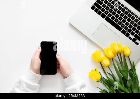 Smartphone entre les mains des femmes sur fond blanc, vue du dessus. Banque D'Images