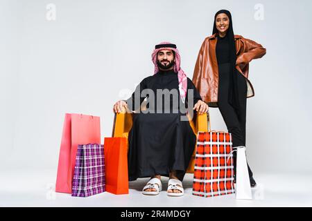 Beau moyen-Orient saoudien couple heureux d'amoureux portant l'abaya traditionnelle et thwab en studio - arabe musulman personnes adultes collage et s. Banque D'Images