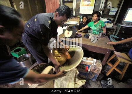 Les gens dépagent des grains de café non torréfiés dans un distributeur de café Toraja à Rantepao, dans le nord de Toraja, dans le sud de Sulawesi, en Indonésie. Le café, l'un des produits agricoles les plus commercialisés, soutient actuellement les moyens de subsistance d'environ 100 millions de personnes dans le monde, selon une équipe de chercheurs de l'Université Rutgers, publiée dans SciTechDaily sur 3 juillet 2021. Rien qu'en Indonésie, une donnée de 2018 du Ministère de l'agriculture citée par Antara montre qu'il y a au moins 1,8 millions de familles de caféiculture. Banque D'Images