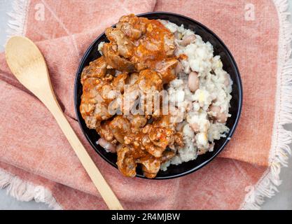 Foies de poulet traditionnel sud-africain Peri Peri avec samp et haricots sur tissu sud-africain traditionnel Banque D'Images