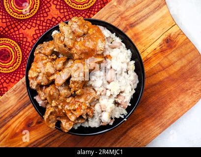 Foies de poulet traditionnel sud-africain Peri Peri avec samp et haricots sur tissu sud-africain traditionnel Banque D'Images