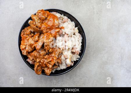 Foies de poulet traditionnel sud-africain Peri Peri avec samp et haricots sur le gris Banque D'Images