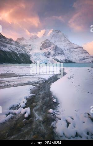 Le mont Robson de la Colombie-Britannique est vu au début de l'hiver, alors qu'une tempête se dissipe au lever du soleil. Banque D'Images