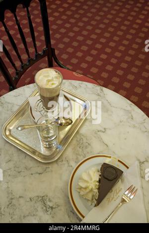 Une tranche de gâteau Sacher-Torte original à la crème fouettée et à l'Ein chaud Banque D'Images
