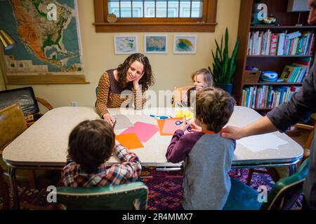 Une famille heureuse fait du papier artisanal à la table de la salle à manger Banque D'Images