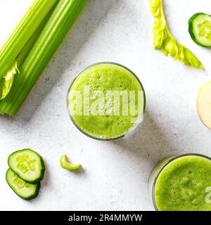 Jus de légumes verts ou smoothie dans des verres. Jus de detox frais pressés et bouquet de céleri biologique, concombre, pomme. Banque D'Images
