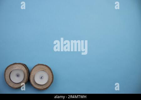 Petites billes et bougies placées horizontalement sur le bord d'un fond bleu, photographiées d'en haut. Banque D'Images