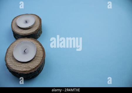 Petites billes placées sur le bord de l'arrière-plan bleu, photographiées d'en haut, avec des bougies à l'intérieur Banque D'Images