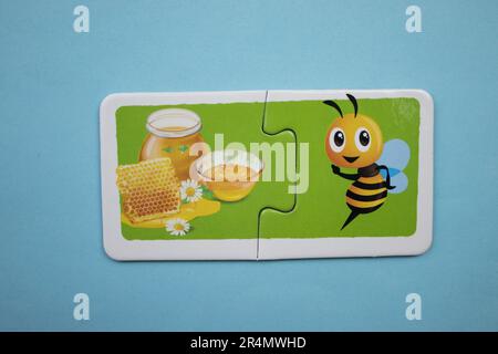 Casse-têtes d'images superposés sur fond bleu. Miel et abeille photographiés d'en haut. Banque D'Images