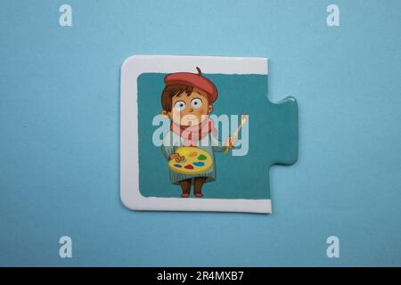 Casse-têtes d'images superposés sur fond bleu. Peintre photographié d'en haut. Banque D'Images