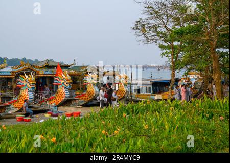 Plusieurs bateaux-dragons amarrés sur la rivière des parfums et des gens de la région qui vivent au quotidien sur la rive de Hue, au Vietnam. Banque D'Images