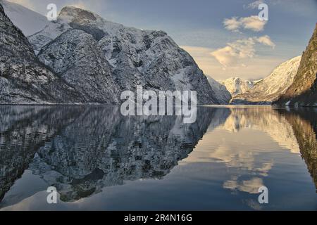 Croisière en ferry de Flam à Gudvangen en Norvège - Aurlandsfjord entouré de montagnes enneigées reflétées dans les eaux calmes du fjord Banque D'Images