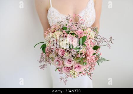 Mariée anonyme avec bouquet rose de fleurs Banque D'Images