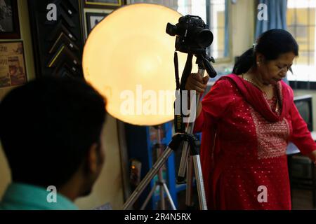 29 mai 2023, Katmandou, Népal: Maiya Shrestha, une femme de 70 ans, Se prépare à prendre la photo d'un client au format passeport à Memory Concern sur New Road, Népal, lundi, 29 mai 2023. Elle a appris des compétences en informatique et en imprimante à l'âge de 54 ans. Auparavant, j'ai travaillé comme assistant bancaire à la banque Rastariya Banijya. Après la naissance de notre fils, mon mari m'a suggéré de me joindre à lui dans son magasin de photographie. Depuis, je travaille dans ce domaine. Dans le passé, nous avions beaucoup de clients, en particulier pendant des festivals comme Dashain. Cependant, nous avons dû envoyer les photos à Bangkok pour le développement à cette époque Banque D'Images