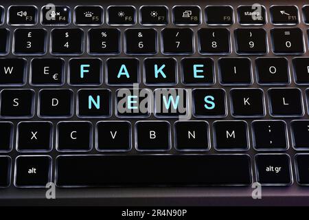 Fausses nouvelles écrites sur les touches d'un clavier d'ordinateur portable rétroéclairé.concept pour diffuser des fausses nouvelles Banque D'Images