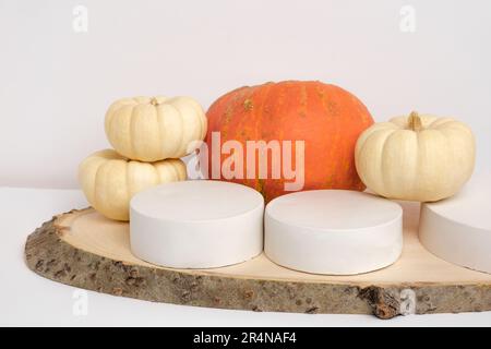 Podium pour la présentation sur un stand en bois avec décoration en forme de citrouille d'automne sur fond de mur blanc. Forme géométrique moderne. Sphère de cylindre. Scène à sh Banque D'Images