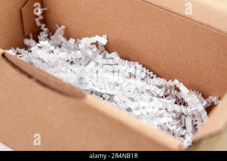 Emballage d'une boîte en carton avec un mastic de protection en plastique blanc pour les objets fragiles en gros plan Banque D'Images